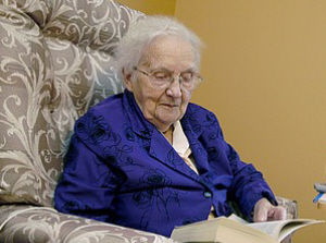old_lady_sitting_in_a_chair_reading_a_book